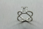 infinity inspired platinum and diamond ring with an emerald cut diamond